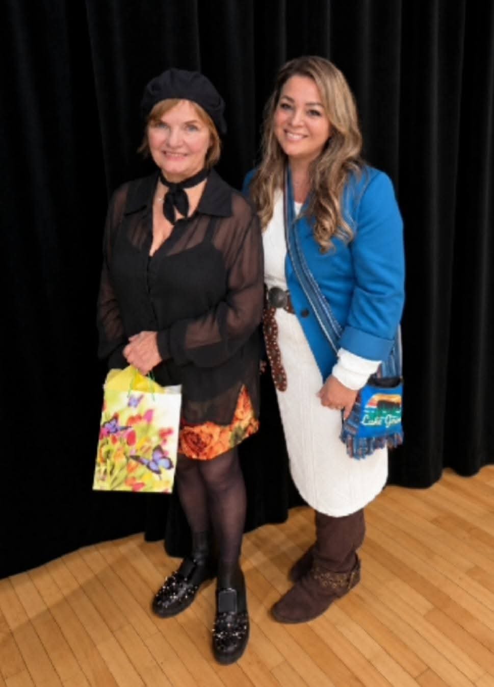 Cindy Roy avec Diane Tell à Petit-Rocher — Diane Tell à gauche, en noir avec un béret, et Cindy Roy à droite, en veste bleue et robe blanche, debout côte à côte devant un rideau noir